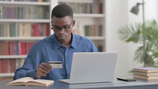 Opgewonden jonge Afrikaanse man winkelen Online op laptop — Stockvideo