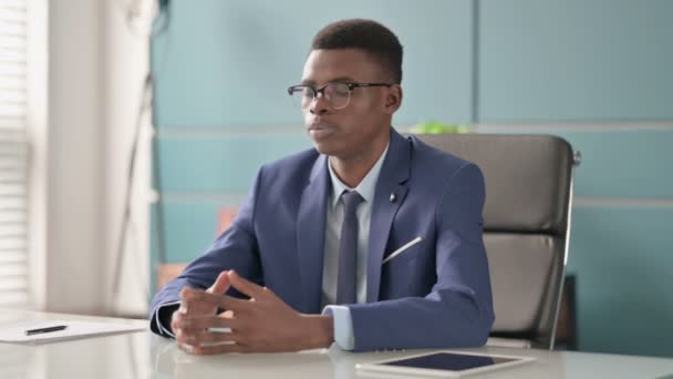 Νεαρός Αφρικανός επιχειρηματίας με πονοκέφαλο που κάθεται στο γραφείο — Αρχείο Βίντεο