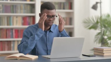 Genç Afrikalı Adam dizüstü bilgisayarla uğraşırken baş ağrısı çekiyor