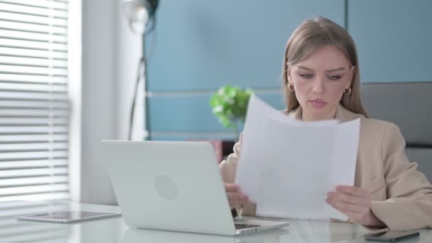 O femeie de afaceri citește rapoarte în timp ce folosește laptop-ul — Videoclip de stoc