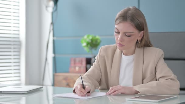 Empresaria escribiendo en papel en la oficina — Vídeo de stock