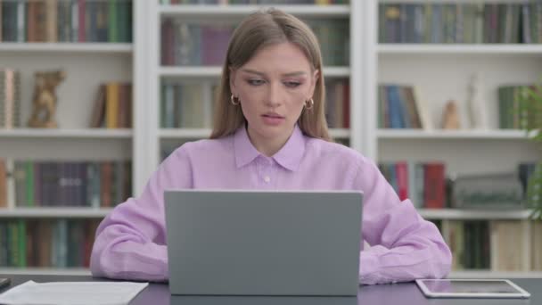 Жінка показує великі пальці вниз знак під час використання ноутбука в офісі — стокове відео