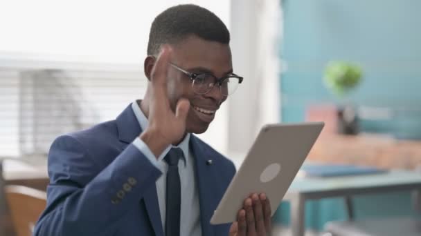 Videollamada en Tablet por un joven empresario africano en la oficina — Vídeos de Stock