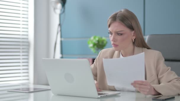 Деловая женщина расстроена во время чтения документов на работе — стоковое видео