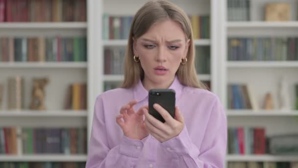 Portret kobiety reagującej na utratę na smartfonie — Wideo stockowe