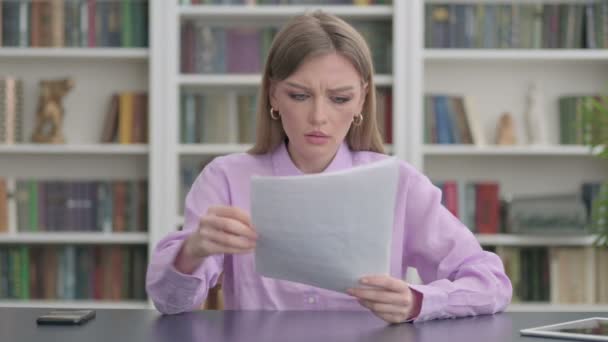 Frau beim Lesen von Dokumenten im Büro verärgert — Stockvideo