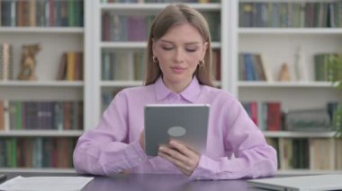 Ofiste otururken Tablet kullanan kadın