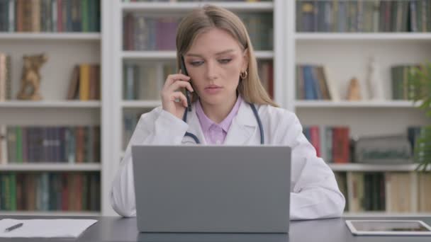 Леди Доктор разговаривает по телефону во время использования топа в клинике — стоковое видео