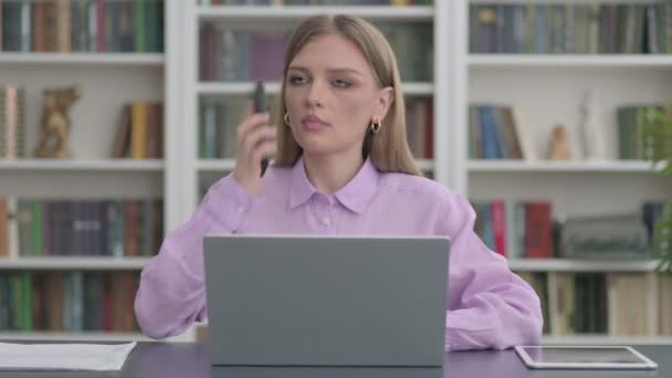 Mujer Hablando en Smartphone mientras usa el ordenador portátil en la oficina — Vídeos de Stock