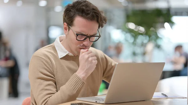 Jeune homme avec ordinateur portable tousse dans le bureau — Photo