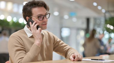 Genç adam Smartphone 'da konuşuyor, ofiste. 