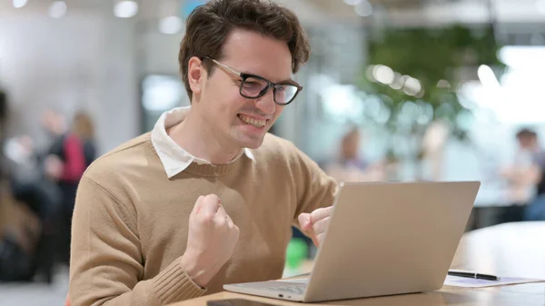 Joven con portátil celebrando en la oficina — Foto de Stock