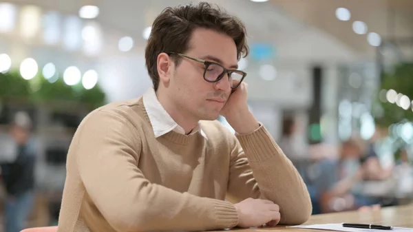 Beau jeune homme faisant la sieste au bureau — Photo