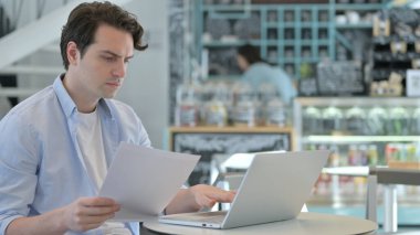 Cafe 'de Dizüstü bilgisayarlı Yaratıcı Adam Okuma Belgeleri 