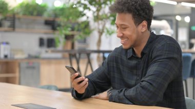 Akıllı telefon kullanırken Afrikalı Amerikalı Adam Kutlama yapıyor