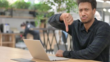 Dizüstü bilgisayarlı Afrikalı Amerikalı Adam 'dan Başparmak İndirme İşareti 