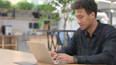 Ofiste dizüstü bilgisayarda çalışan Afrikalı Amerikalı adam. 