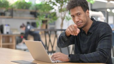 Bilgisayarlı Afrikalı Amerikalı Kamerayı işaret ediyor 