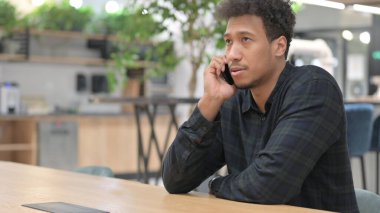 İş yerinde Afro-Amerikan Adam Akıllı Telefonla Konuşuyor 