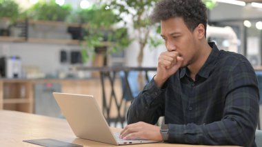 Laptoplu Afrikalı Amerikalı Adam öksürüyor. 
