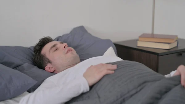 Homem acordando do sono na cama — Fotografia de Stock