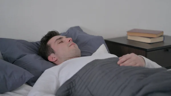 Homem dormindo na cama pacificamente — Fotografia de Stock