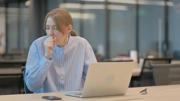 Mulher jovem tosse ao usar laptop no escritório — Fotografia de Stock