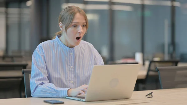 Mladá žena reaguje na ztrátu během používání notebooku — Stock fotografie