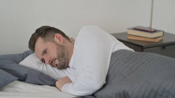 Człowiek niezdolny do spania w łóżku — Zdjęcie stockowe