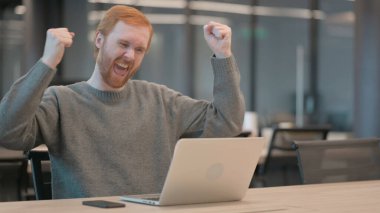 Ofiste dizüstü bilgisayar kullanırken Başarı Kutlaması Genç Adam