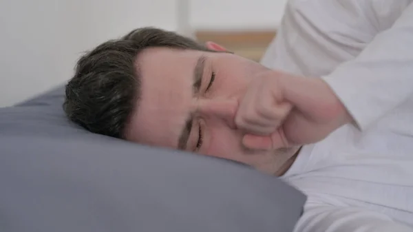 ベッドで寝ている間に男が咳をし、閉じる — ストック写真