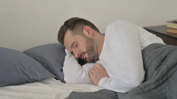 Människan sover lugnt i sängen — Stockfoto