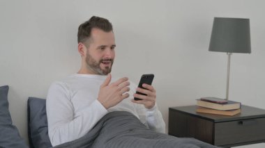 Çevrimiçi Başarıyı Kutlayan Adam Yatakta Akıllı Telefon 'da