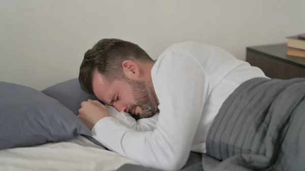Homem chorando enquanto dormia na cama — Fotografia de Stock