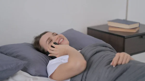 Frau telefoniert während sie im Bett schläft — Stockfoto