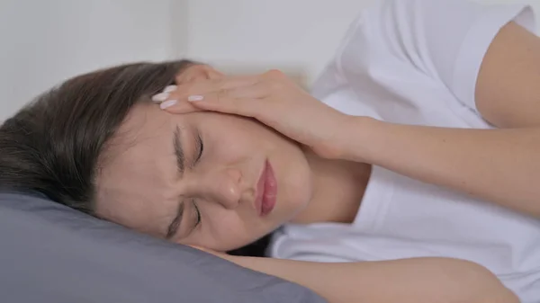 Frau hat Kopfschmerzen beim Schlafen im Bett — Stockfoto