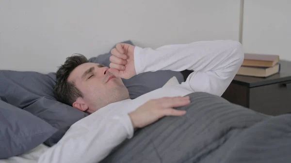 Ο άνθρωπος βήχει ενώ κοιμάται στο κρεβάτι — Φωτογραφία Αρχείου