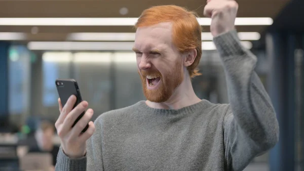 Portret van een jonge man viert feest op smartphone — Stockfoto