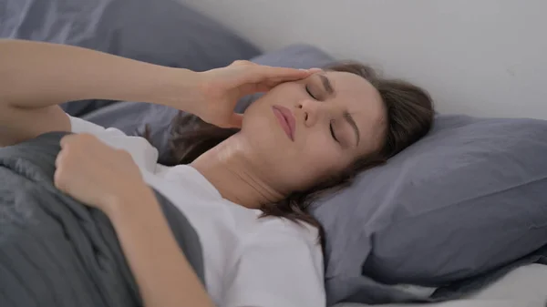Frau hat Kopfschmerzen beim Schlafen im Bett — Stockfoto