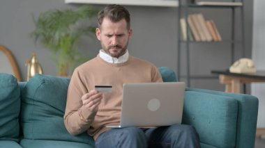 Kanepede Dizüstü bilgisayarında Başarısız Çevrimiçi Ödeme Yapan Adam 