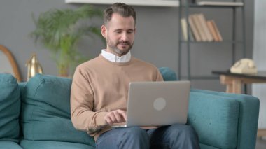 Kanepede Dizüstü bilgisayarda çalışan adam 