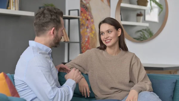 Casal conversando enquanto sentado no sofá — Fotografia de Stock