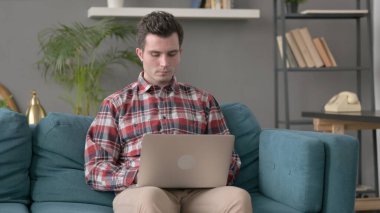 Kanepede Dizüstü bilgisayarda çalışan adam 