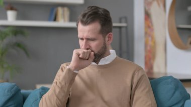 Evde otururken öksüren adamın portresi