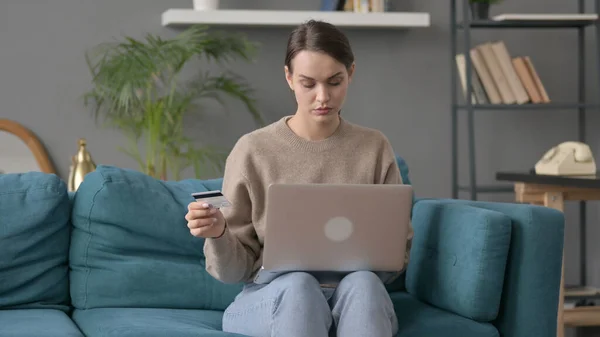 Женщина делает онлайн оплату на ноутбуке на диване — стоковое фото
