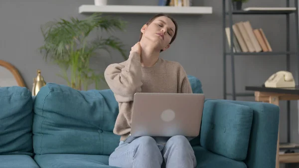 Femme avec ordinateur portable ayant la douleur au cou sur le canapé — Photo