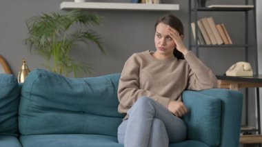 Kadın koltukta otururken baş ağrısı çekiyor 