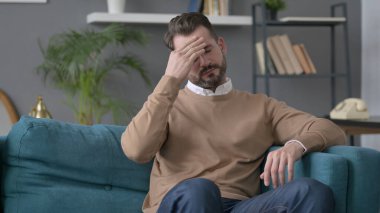 Koltukta oturan adamın başı ağrıyor. 