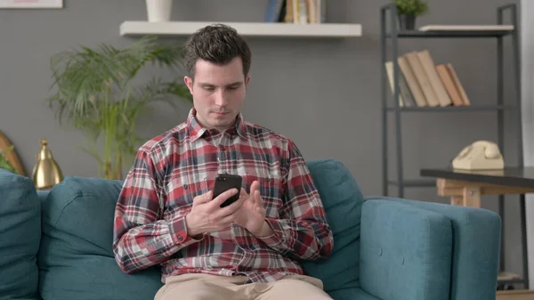 Man using Smartphone on Sofa