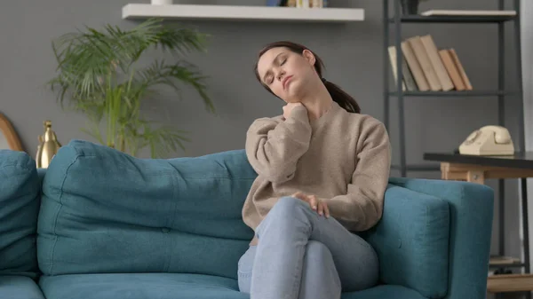 Nő birtoklás nyaki fájdalom, miközben ül a kanapén — Stock Fotó
